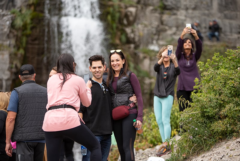 Coaches taking selfies in front of a waterfall at Stewart Falls.